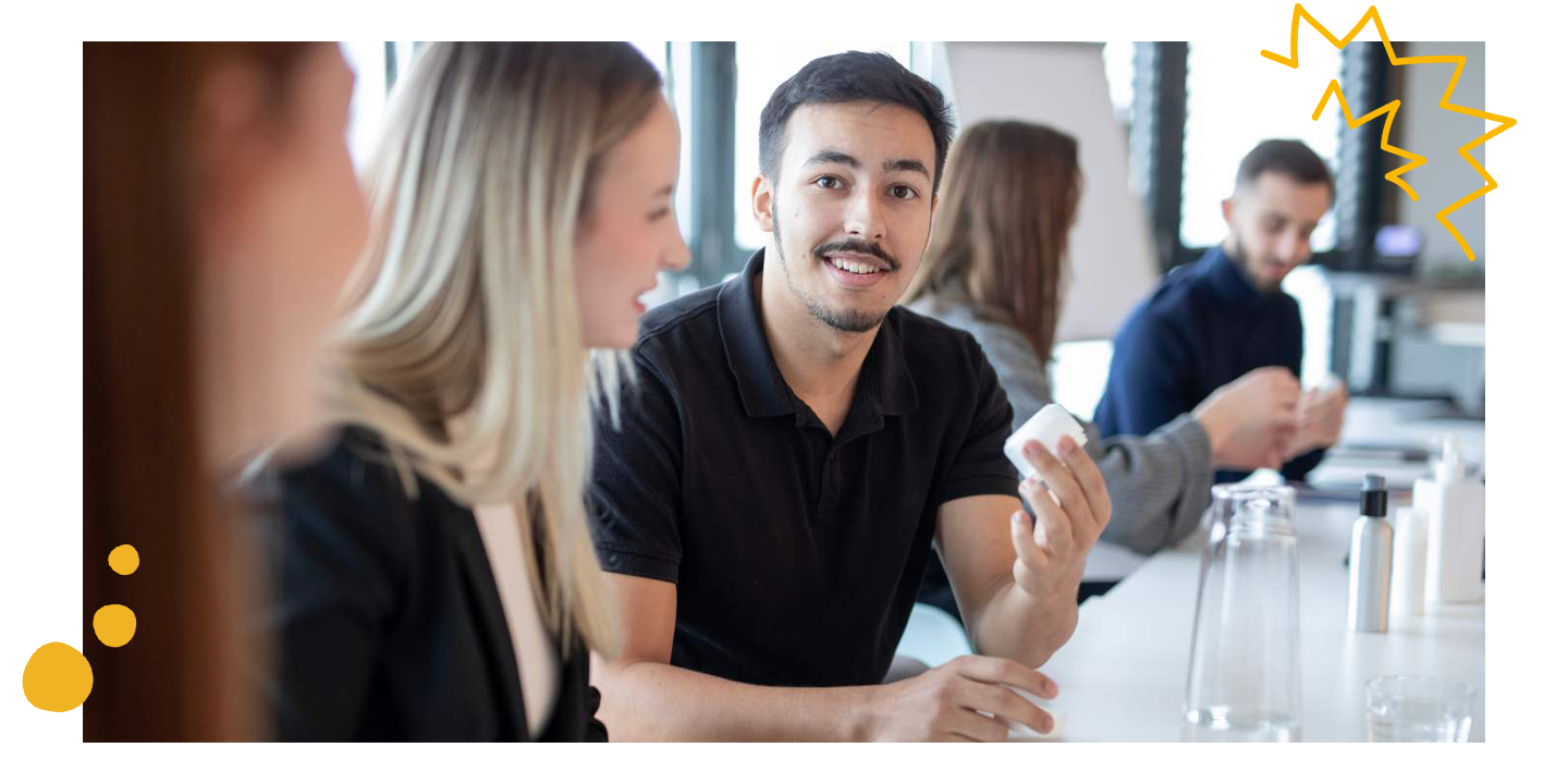 Junge macht Ausbildung bei Mann & Schröder und lächelt mit Kosmetikprodukt in der Hand