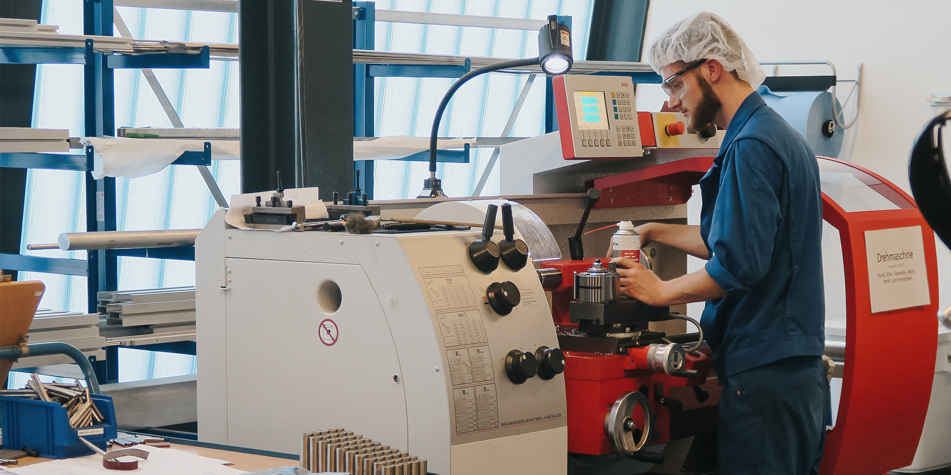 Auszubildender arbeitet an moderner Maschine in der Lehrwerkstatt
