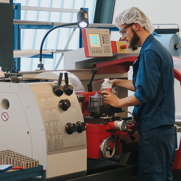 Auszubildender arbeitet an moderner Maschine in der Lehrwerkstatt